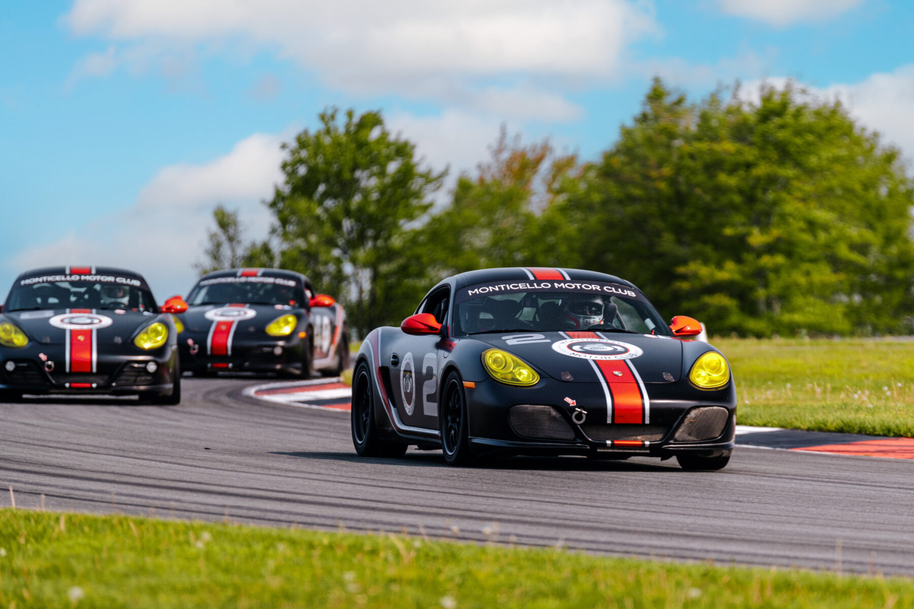 a group of Porsche idk race school cars racing on track